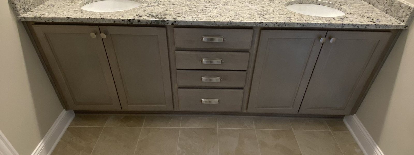 Finished bathroom vanity with a granite top and undermount sinks