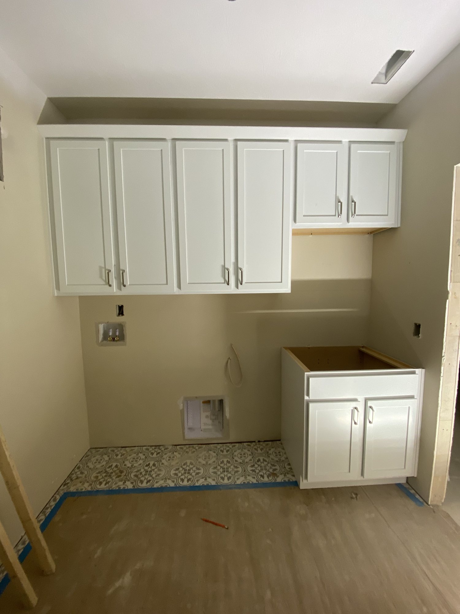 White cabinetry set in a utility kitchen before tops and trim