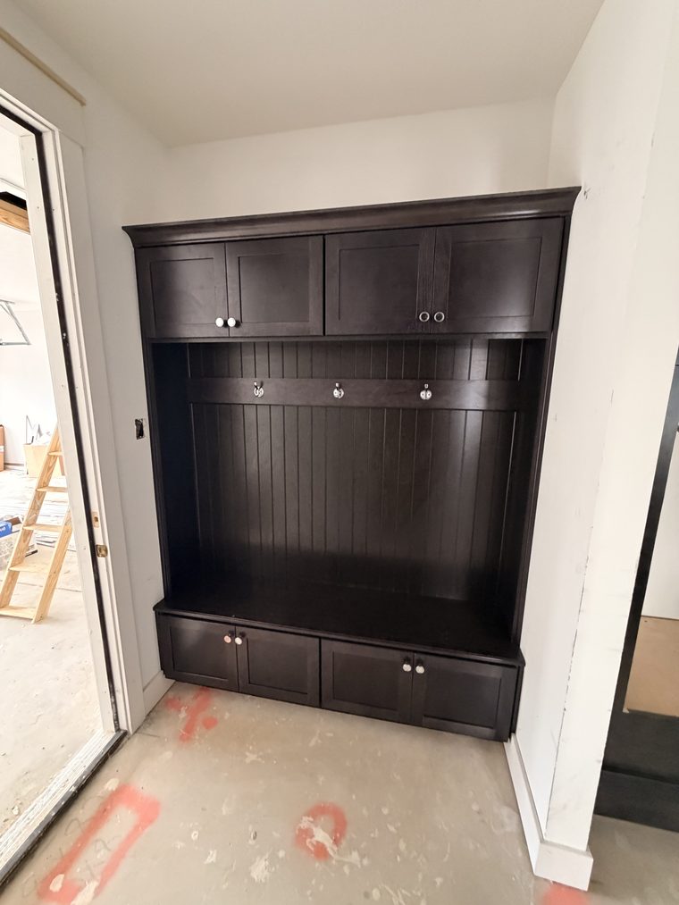 Mudroom lockers in dark beadboard with hooks, bench seat and drawers
