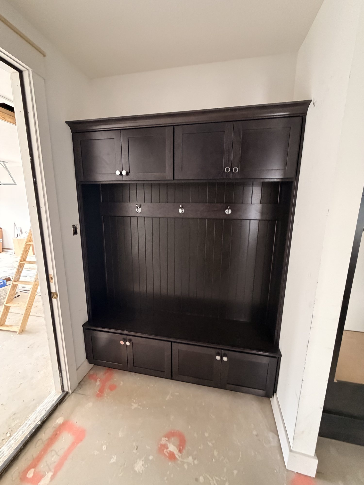Mudroom lockers in dark beadboard with hooks, bench seat and drawers
