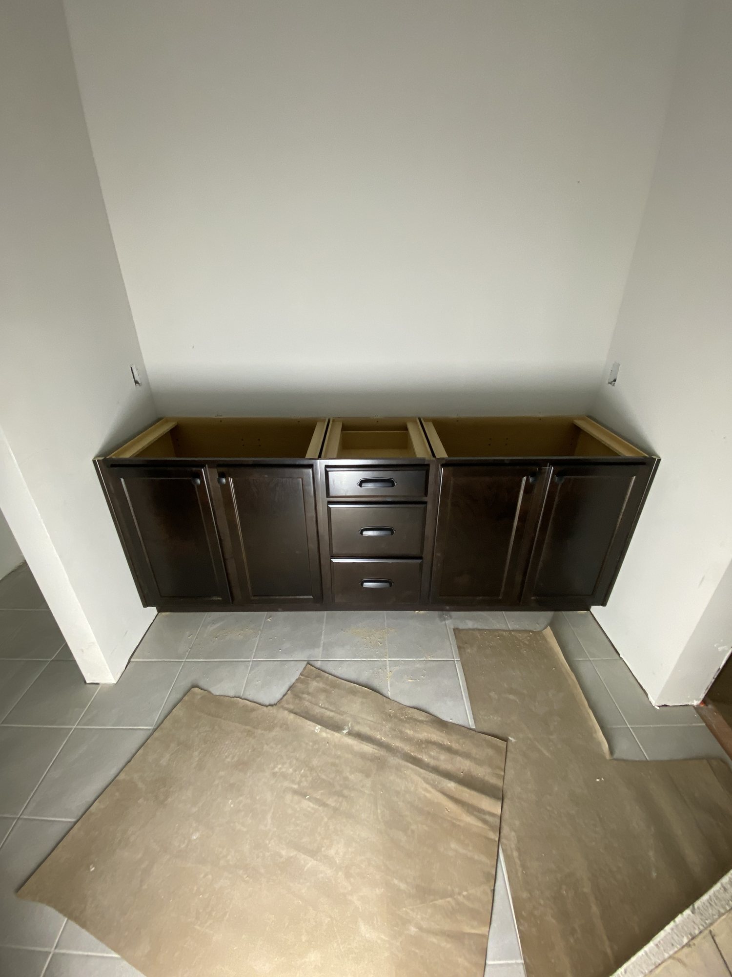 Long run of dark cabinetry set over tile