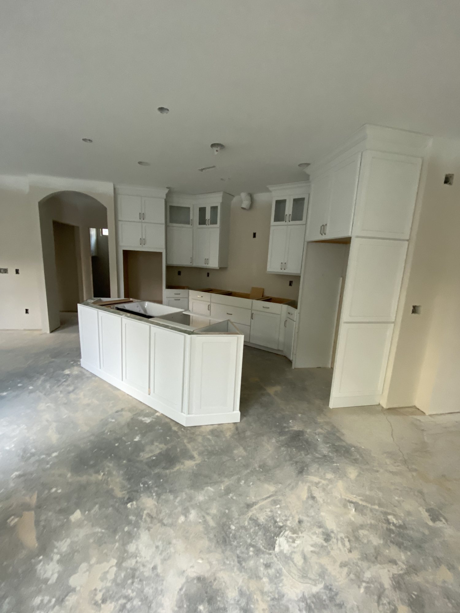 White kitchen cabinetry and island set in an open-plan room