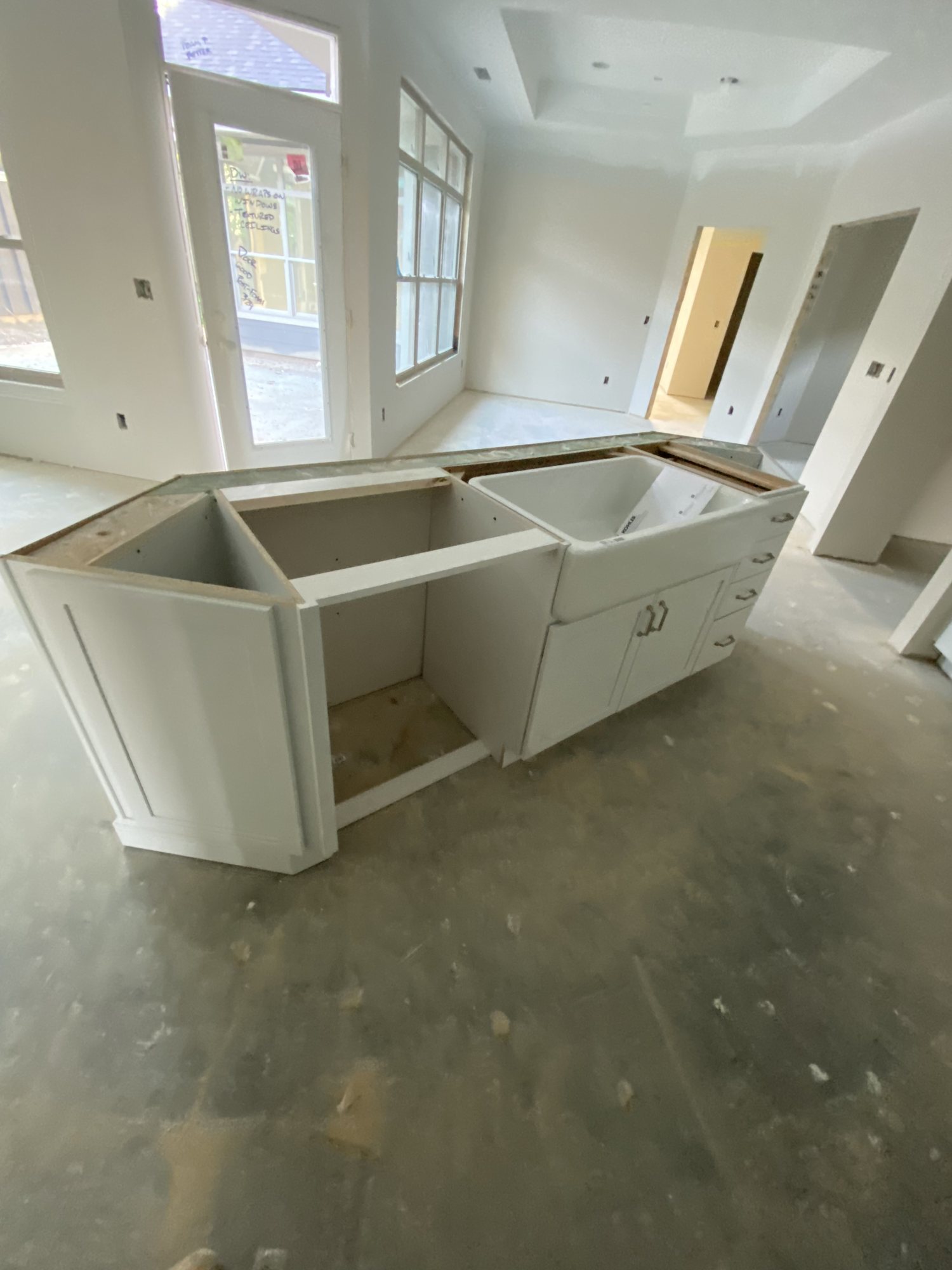 White island with a farmhouse sink set in a bay-window kitchen